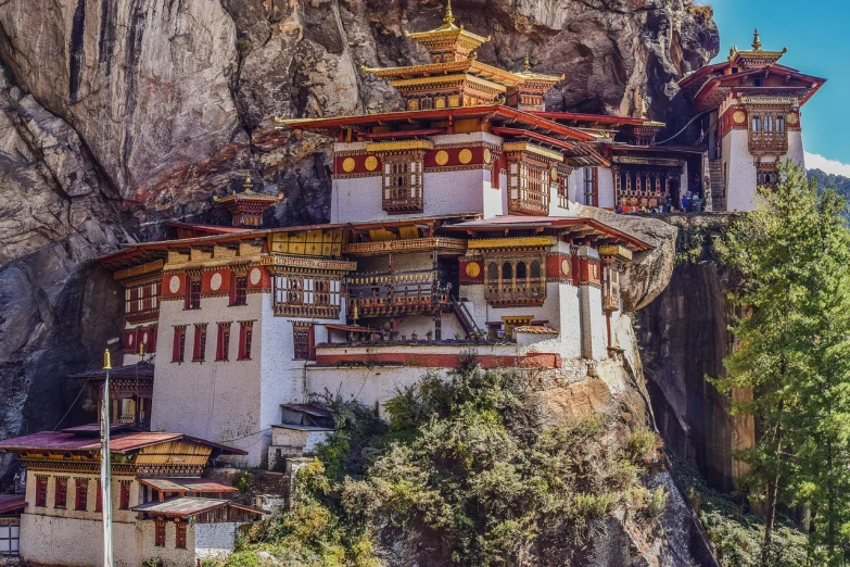 a large white building sitting on top of a cliff, inspired by Shūbun Tenshō, trending on pixabay, renaissance, bhutan, full of colors and rich detail, full morning sun, buzzed hair on temple