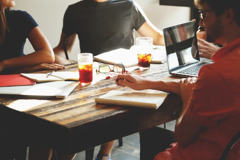 a group of people sitting around a wooden table, a picture, pexels, working hard, marketing photo, 4 0 9 6, clear focused details