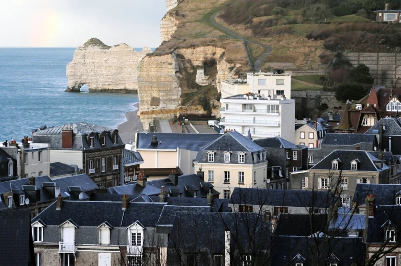 a view of a city with a rainbow in the sky, a tilt shift photo, by Raphaël Collin, figuration libre, chalk cliffs above, january, normandy, the photo shows a large