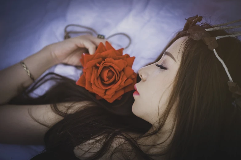 a woman laying down with a rose in her mouth, a picture, by Ayami Kojima, tumblr, avatar image, red flower, sleeping beauty, with long hair and piercing eyes