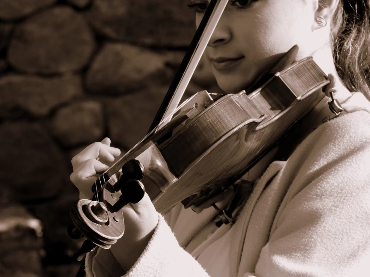 a black and white photo of a young girl playing a violin, a picture, by Eugeniusz Zak, flickr, sepia tone, close up half body shot, accurate and detailed, stock photo