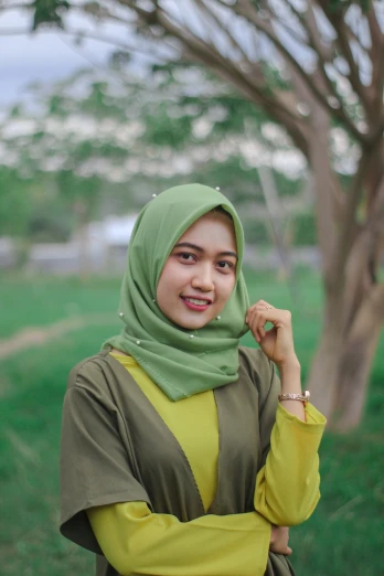 a woman in a green hijab talking on a cell phone, a picture, inspired by Nazmi Ziya Güran, shutterstock, hurufiyya, 🤤 girl portrait, portrait of a cute girl, square, in a field