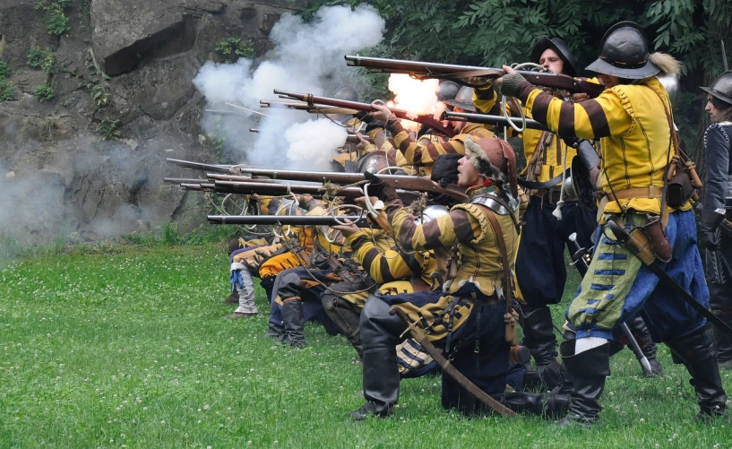 a group of men that are standing in the grass, flickr, renaissance, muzzle flash, in full military garb, yellow robes, quebec