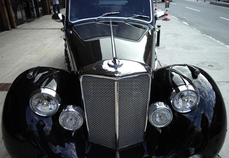a classic car is parked on the side of the street, by Jay Hambidge, flickr, art deco, transparent black windshield, manhattan, shiny knobs, panzer