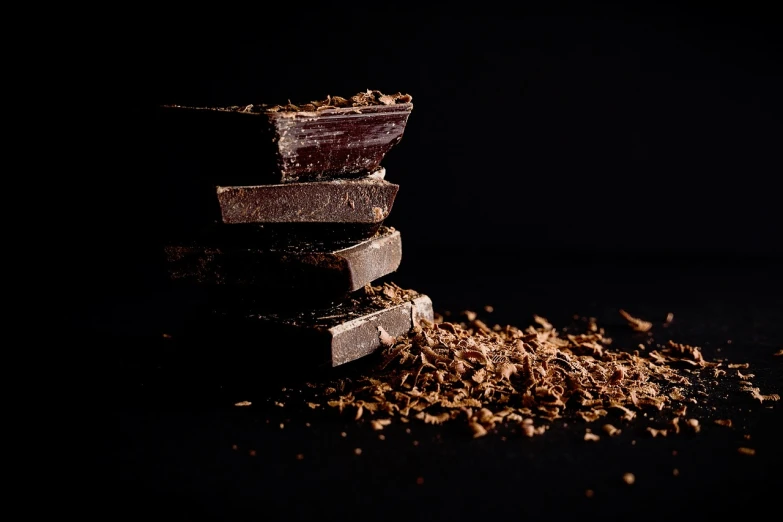 a pile of chocolate sitting on top of a table, a picture, by Matthias Weischer, deep black, spices, bark, 4 k product photo