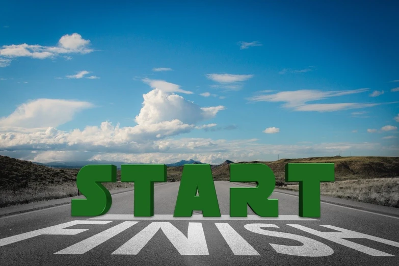 a green start finish sign sitting on the side of a road, a picture, by Kurt Roesch, pixabay, happening, in the style of john baldessari, unfinished, stock photo