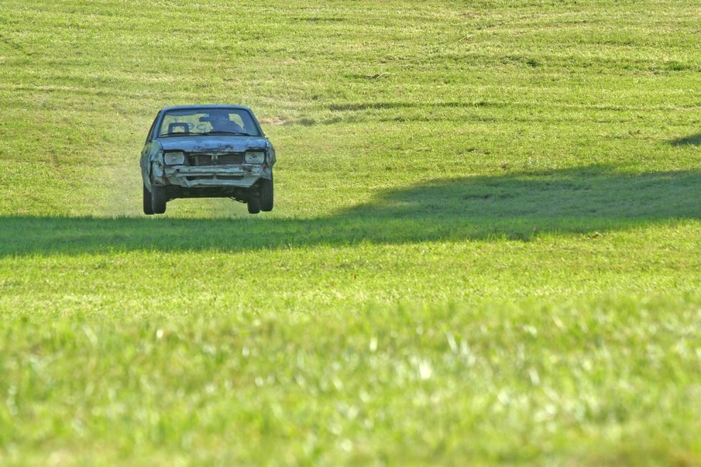 a car that is sitting in the grass, by Richard Carline, flickr, renaissance, car chase scene, at racer track, scrape off, panoramic