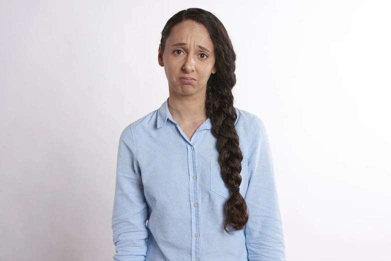 a woman with long hair wearing a blue shirt, antipodeans, sad exasperated expression, mixed race, woman with braided brown hair, on clear background