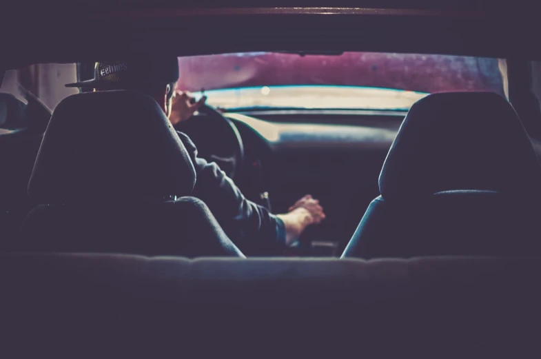 a man sitting in a car talking on a cell phone, a picture, by Elsa Bleda, shutterstock, visual art, retro effect, inside the tunnel, steering wheel, anonymous as a car