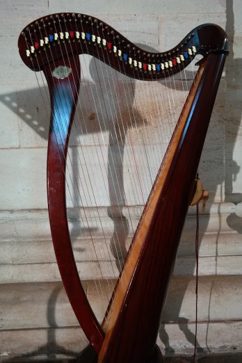 a close up of a harp near a wall, inspired by Balázs Diószegi, flickr, cable plugged into cyberdeck, on the altar, france, symmetrical front view