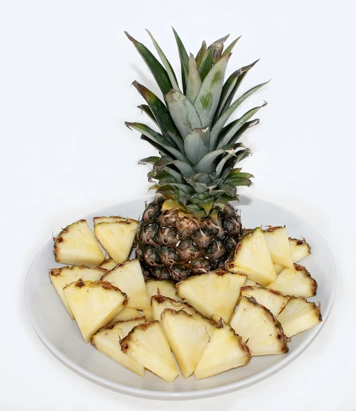 a white plate topped with sliced pineapples, a photo, istockphoto, high res photo, pyramid, indoor