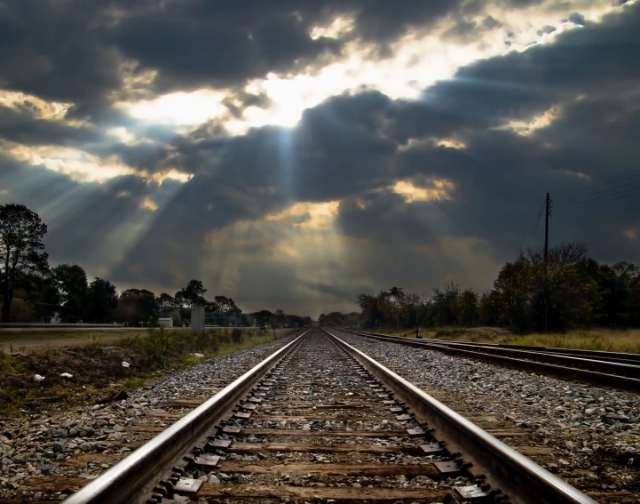 a train track with the sun shining through the clouds, a portrait, by David Burton-Richardson, flickr, realism, from wheaton illinois, rays of god, stock photograph, photo still