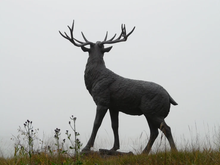 a statue of a deer on top of a hill, by John Henderson, flickr, new sculpture, under a gray foggy sky, very very high detailed, elk, moor