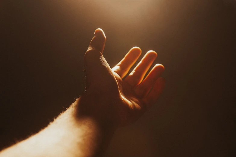 a person holding their hand up in the air, a picture, light and space, harsh overhead sunlight, on a dark background, the futility of overexertion, profile picture