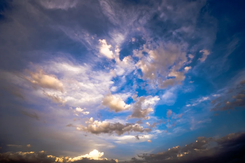 a large body of water under a cloudy sky, a picture, shutterstock, romanticism, colorful dramatic puffy clouds, cinematic view from lower angle, blue sky at sunset, ceremonial clouds