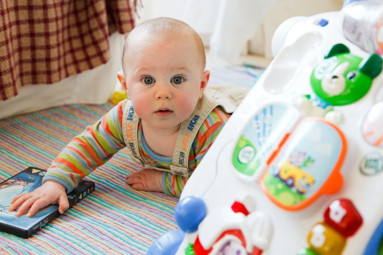 a baby laying on the floor playing with a cell phone, by Juan O'Gorman, shutterstock, walking towards camera, toys, avatar image, fisher price