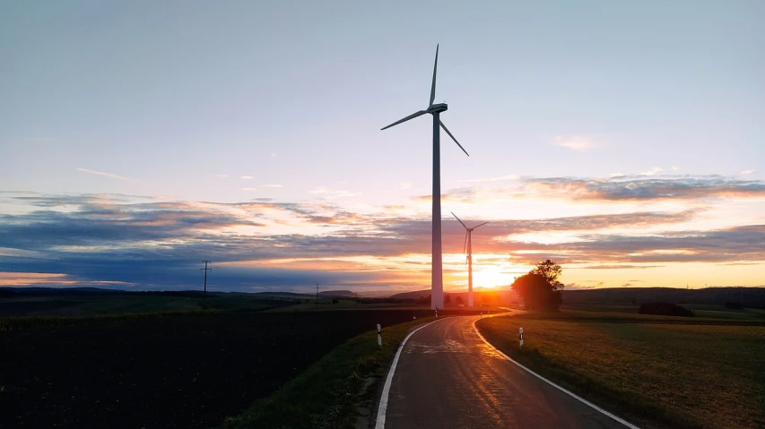 the sun is setting behind a wind turbine, by Thomas Häfner, happening, on a road, 1128x191 resolution, maintenance, lines of energy