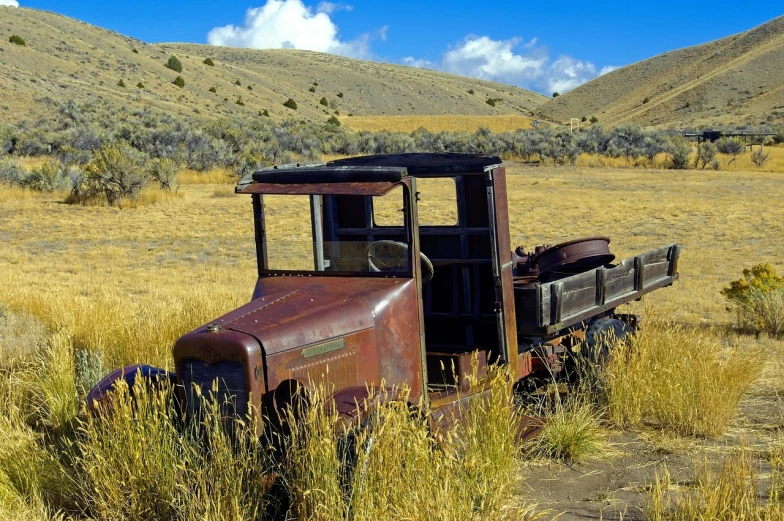 an old truck sitting in the middle of a field, by Dennis Ashbaugh, flickr, canyon, photograph credit: ap, in the hillside, turnaround