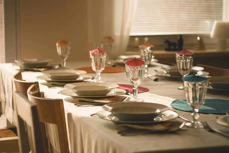 a table that has a bunch of plates on it, a photo, by Jakob Gauermann, shutterstock, filtered evening light, dinner table, stock photo, colorado