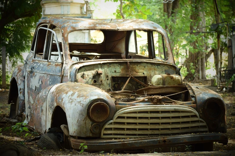 an old rusty car sitting in the middle of a forest, a portrait, by Richard Carline, shutterstock, photorealism, under repairs, the cars have faces, truck, highly ornate