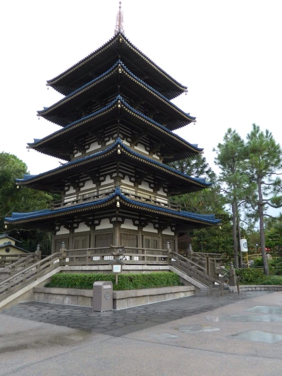 a tall pagoda sitting in the middle of a park, inspired by Gusukuma Seihō, sōsaku hanga, disney!!, elaborate carved wood balconies, ground - level view, in 2 0 1 2