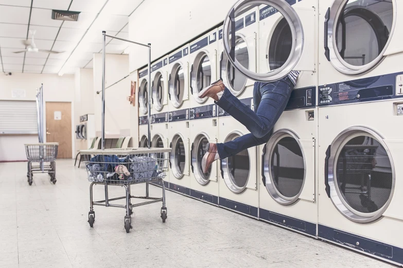 a person jumping in front of a row of washing machines, a stock photo, pexels, istock, giant athanor, postprocessed, funny professional photo