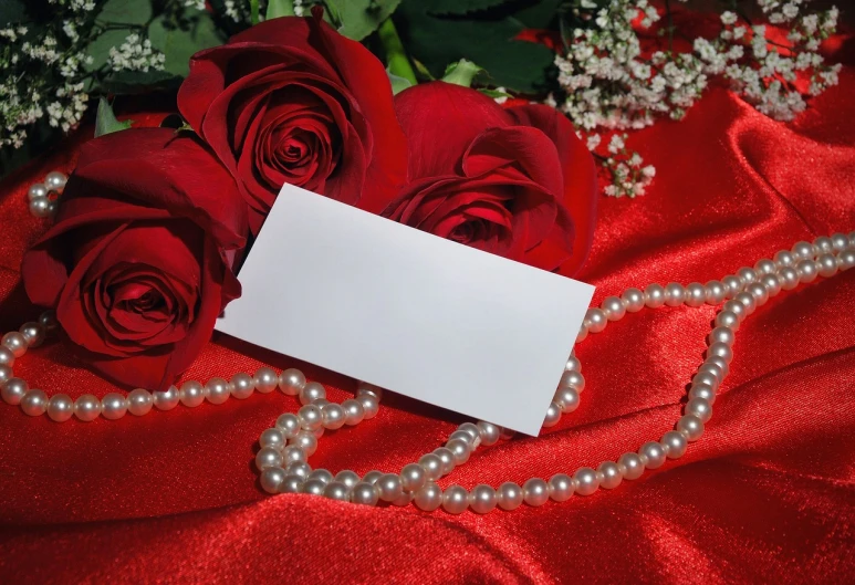 a bunch of red roses sitting on top of a red cloth, a photo, card template, pearl silverplate, wearing white silk, label