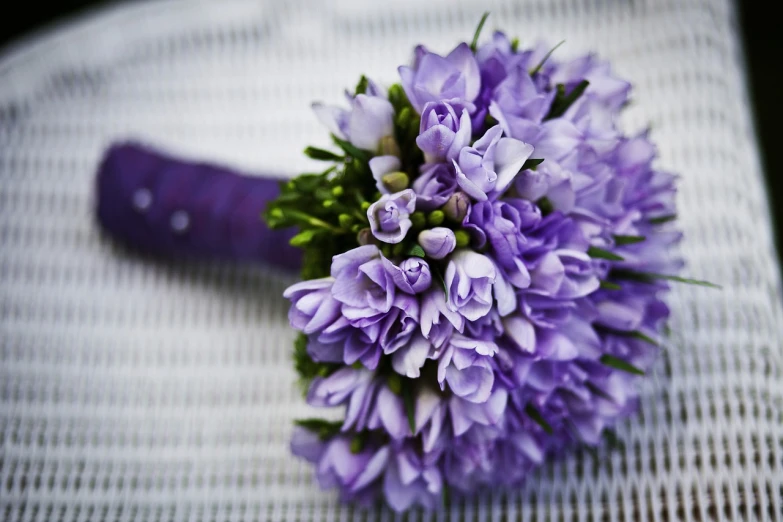 a bouquet of purple flowers sitting on top of a table, inspired by Géza Dósa, pexels, istockphoto, purple cloth, manicured, fully covered