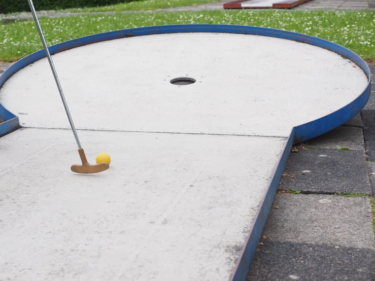 a miniature golf course with a yellow ball on it, a picture, by Jan Rustem, dribble, concrete, half moon, pipe, take off
