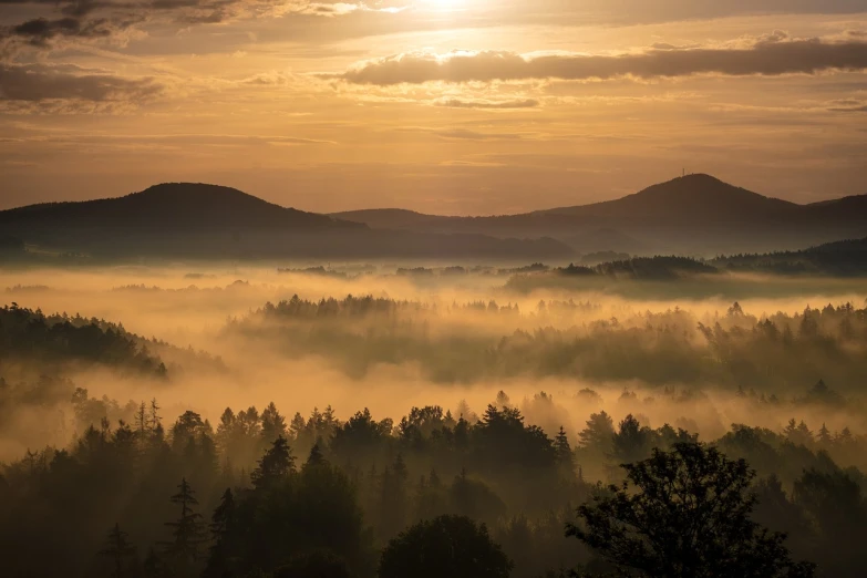 the sun is setting over a foggy valley, by Sebastian Spreng, pexels contest winner, romanticism, beautiful swedish forest view, benjamin vnuk, light orange mist, hills