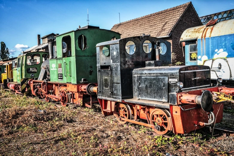 a train that is sitting on the tracks, a colorized photo, by Thomas Häfner, trending on pixabay, junk yard, 3 heads, low dutch angle, old retro museum exhibition