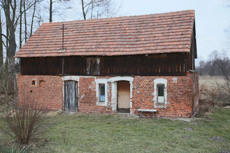 an old brick building sitting in the middle of a field, a portrait, by Petr Brandl, shutterstock, polish mansion kitchen, log cabin, early spring, half body photo