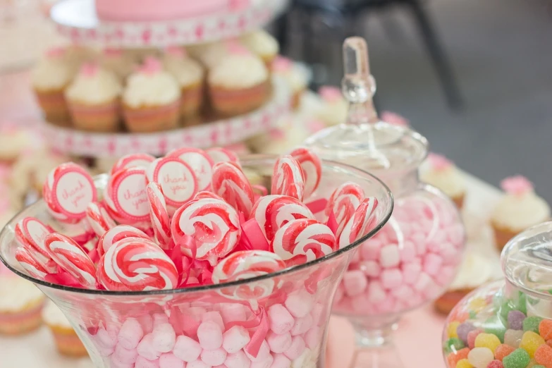 a table topped with lots of candy and cupcakes, by Rhea Carmi, pexels, soft light 4 k in pink, closeup - view, glass tableware, made of candy and lollypops