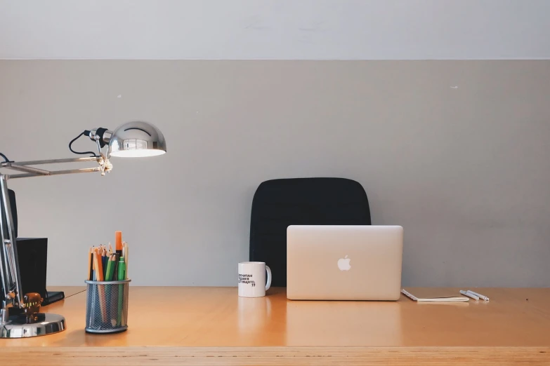 a laptop computer sitting on top of a wooden desk, pexels, light and space, sitting behind desk, empty office, wide screenshot, flat image