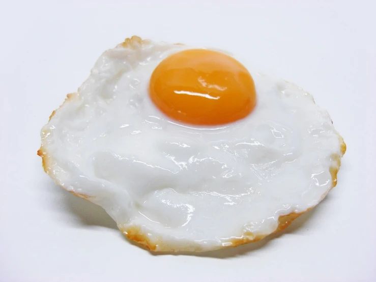 a fried egg sitting on top of a white plate, by Kishi Ganku, flickr, sōsaku hanga, hyper realistic detail, slightly overexposed, wikimedia, close-up view