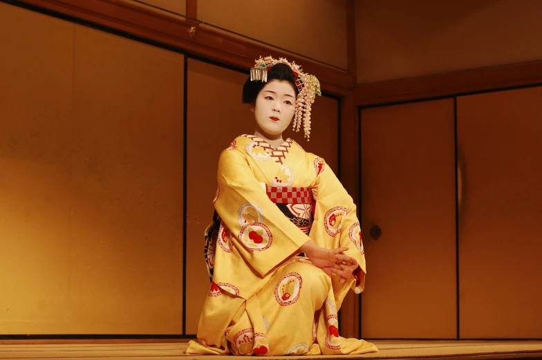 a woman in a kimono sitting on a stage, flickr, high res, dressed in a beautiful, traditional, with yellow cloths