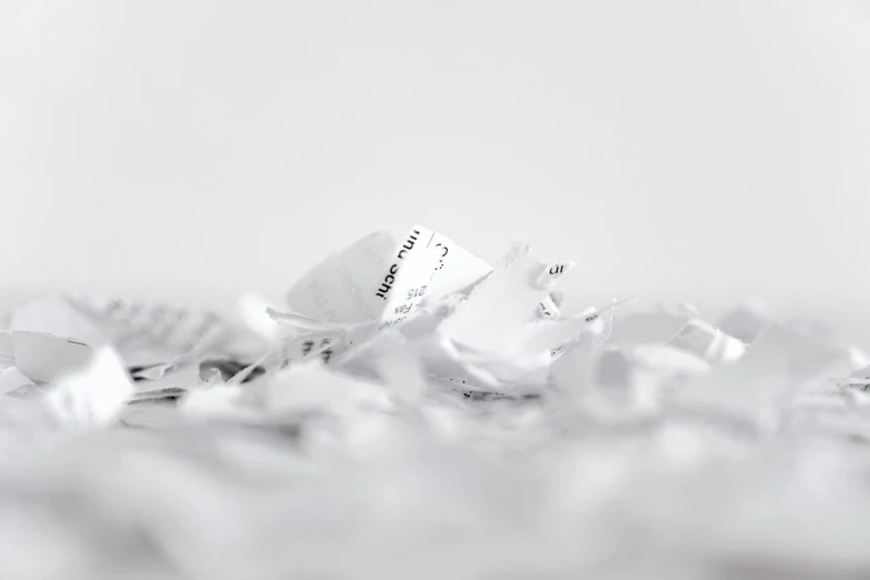 a pile of shredded paper sitting on top of a table, a photocopy, by Matthias Weischer, minimalism, close-up product photo, white ribbon, writings, miniature product photo