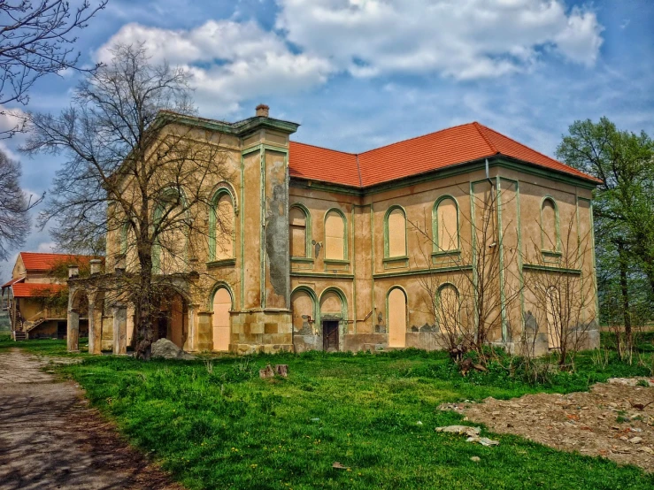 a large building sitting on top of a lush green field, a portrait, inspired by Gyula Aggházy, shutterstock, baroque, in a desolate abandoned house, the narthex, view from the street, warm spring