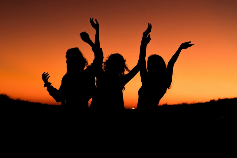 a group of women standing next to each other at sunset, by Alexis Grimou, shutterstock, dance party, backlit!!, black, hippie