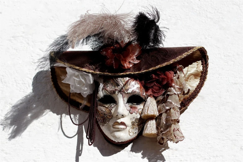 a close up of a mask on a wall, a photo, trending on pixabay, baroque, sombrero, dressed in a frilly ((ragged)), dark sienna and white, on white