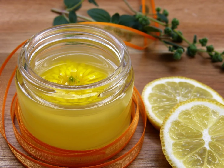 a jar of lemonade with a slice of lemon next to it, by Echo Chernik, hurufiyya, diffused natural skin glow, marigold, jello, cream