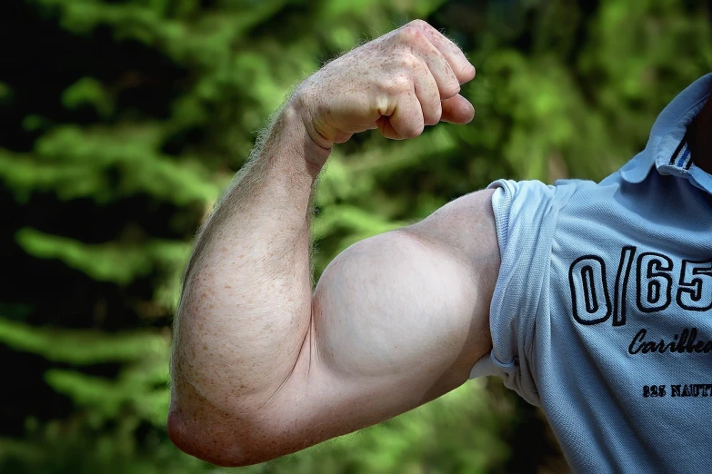 a close up of a person flexing his arm, by Jan Rustem, pixabay, oregon, big biceps, outdoor photo, extremely pale white skin