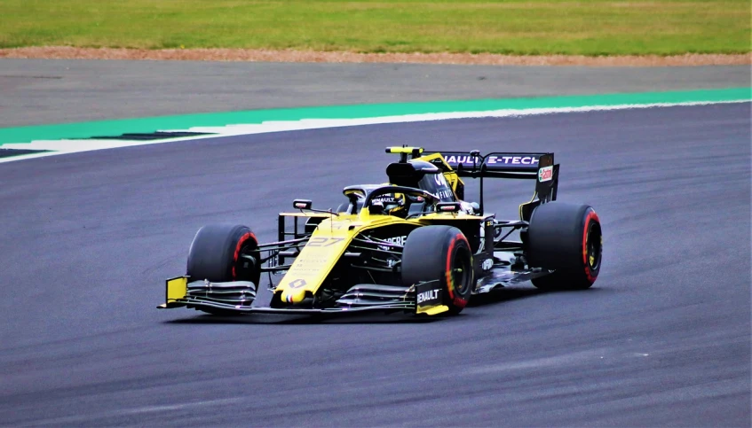 a yellow race car driving on a race track, a picture, inspired by Alonso Vázquez, pexels, yellow and black color scheme, square, daniel ricciardo, silver and yellow color scheme