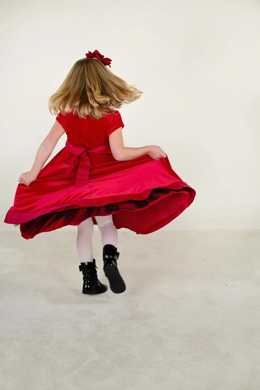 a little girl in a red dress and black boots, inspired by John Everett Millais, arabesque, shot from the back, high res photo, wide shot photo, studio portrait photo