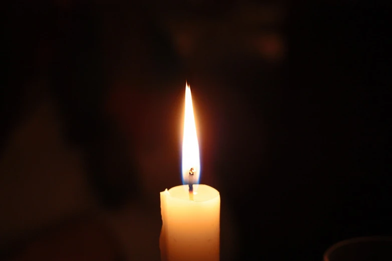 a lit candle sitting on top of a table, a picture, by Tom Carapic, unedited, wikimedia, middle close up shot, light from right