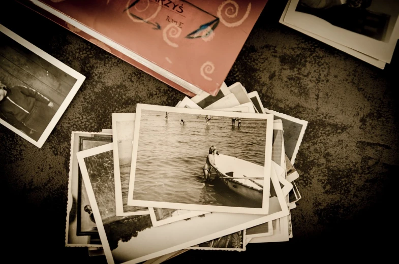 a pile of old photos sitting on top of a table, by Matt Stewart, unsplash, boats, distant memories, sepia, ebay photo