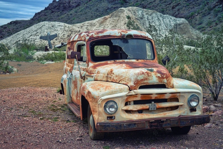 an old rusted truck parked on the side of a dirt road, pexels, photorealism, las vegas, moskvich, stained antique copper car paint, soft color dodge