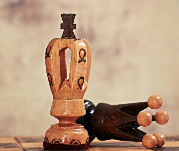 a close up of a wooden object on a table, by Rodney Joseph Burn, shutterstock, renaissance, ( queen chess piece, ankh symbol, handpainted, small crown