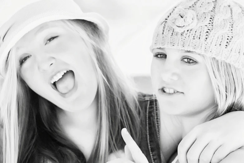 a couple of women standing next to each other, a black and white photo, tumblr, laughing and yelling, young teen, cute hats, closeup photo