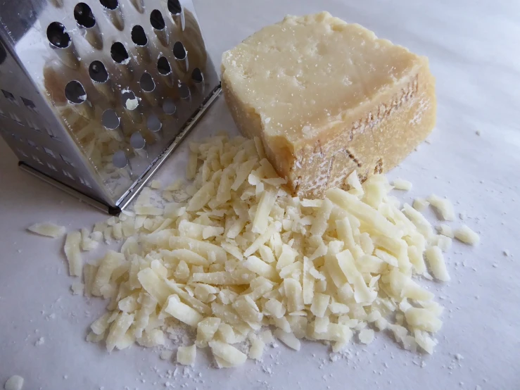 a cheese grater next to a block of cheese, a photo, renaissance, crushed, pale ivory skin, sugar, crisp edges